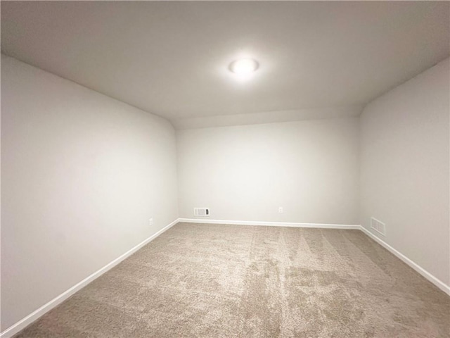 carpeted spare room with visible vents and baseboards