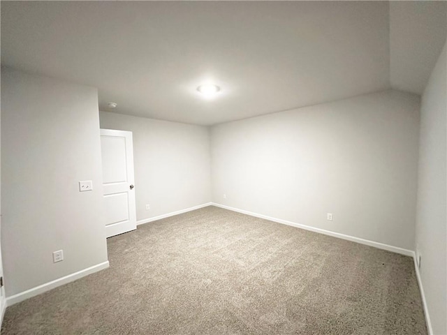 carpeted spare room featuring baseboards