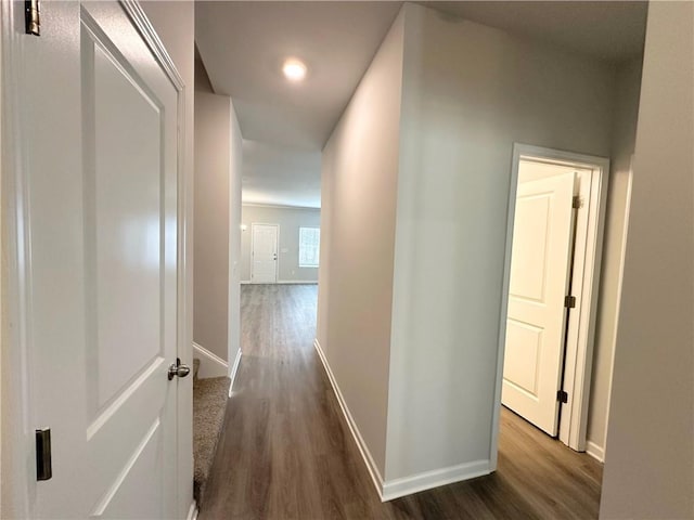 corridor featuring dark wood finished floors and baseboards