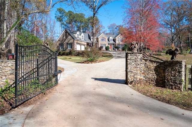 view of road featuring a gate, a gated entry, and concrete driveway