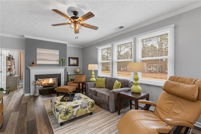 living room with a textured ceiling, visible vents, wood finished floors, and a multi sided fireplace