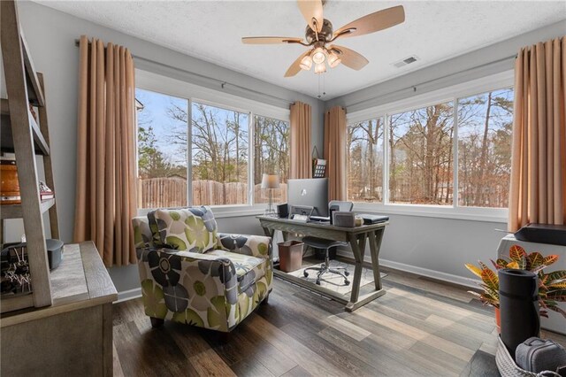 office space with visible vents, a textured ceiling, baseboards, and wood finished floors