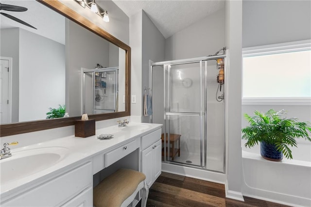 full bathroom with a textured ceiling, lofted ceiling, a sink, a ceiling fan, and a shower stall