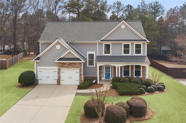 view of front of home featuring a front yard, fence, a garage, stone siding, and driveway