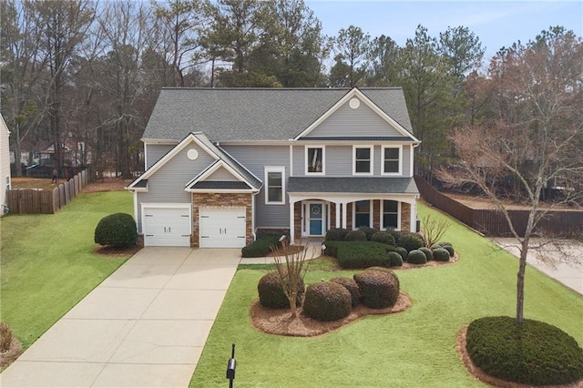 view of front of property featuring a front yard, concrete driveway, and fence