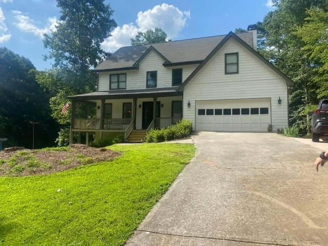 view of front of house featuring a porch, a garage, and a front lawn