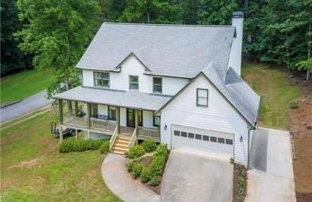 view of front of home with a porch, a garage, and a front lawn