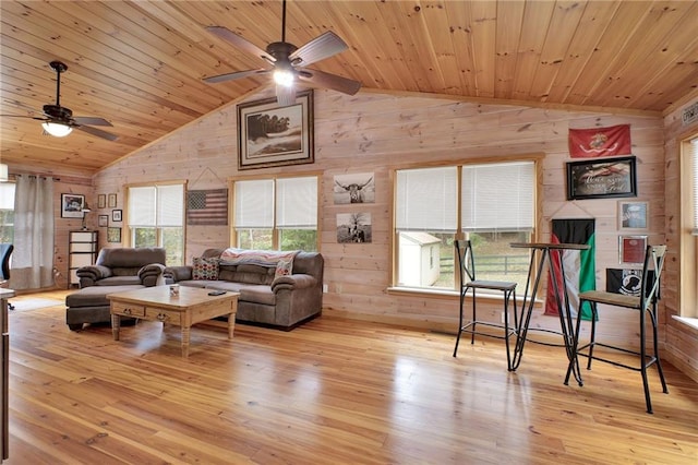 living room featuring a wealth of natural light, wood walls, light hardwood / wood-style floors, lofted ceiling, and wood ceiling