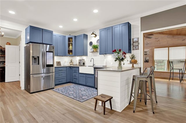 kitchen with ornamental molding, a breakfast bar, blue cabinets, light hardwood / wood-style flooring, and stainless steel fridge with ice dispenser