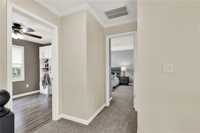 hallway featuring dark carpet and ornamental molding