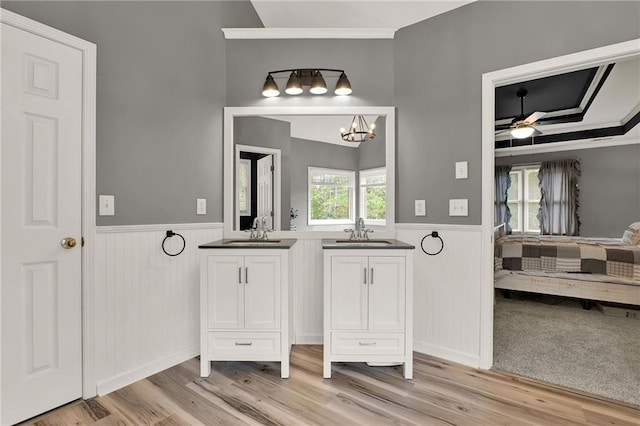 bathroom featuring crown molding, vanity, wood-type flooring, and ceiling fan with notable chandelier