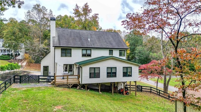 rear view of property with a yard and a wooden deck