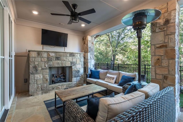 view of patio / terrace featuring ceiling fan and an outdoor living space with a fireplace