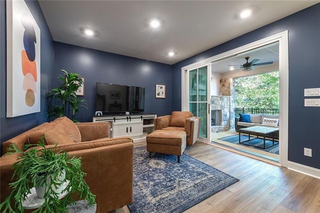 living room with light hardwood / wood-style flooring and ceiling fan