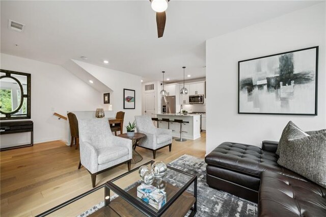 kitchen with light stone countertops, stainless steel appliances, a kitchen island with sink, sink, and white cabinets