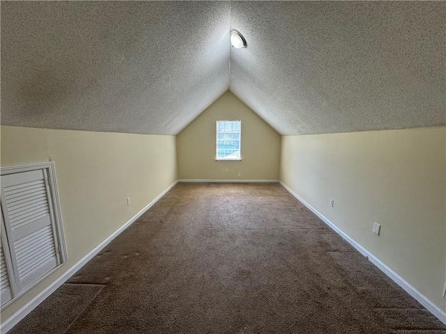 1050 Redan Trce, Stone Mountain, GA 30088 - additional living space featuring a textured ceiling, carpet, lofted ceiling, and baseboards