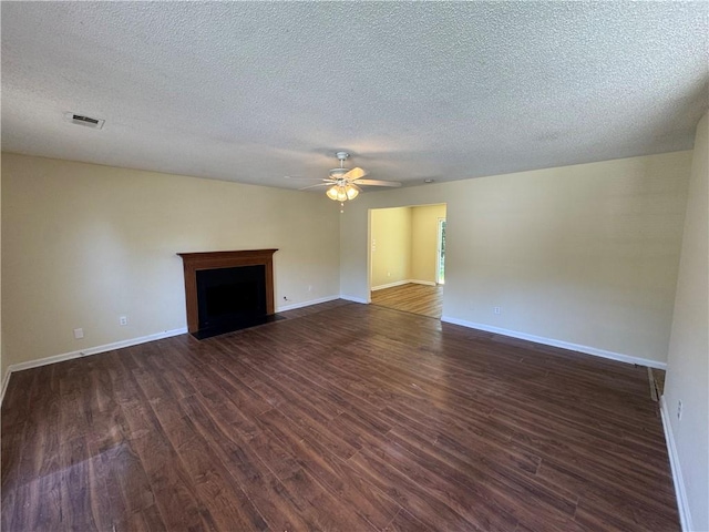 1050 Redan Trce, Stone Mountain, GA 30088 - unfurnished living room with dark wood-style floors, a ceiling fan, a textured ceiling, baseboards, and a fireplace with flush hearth