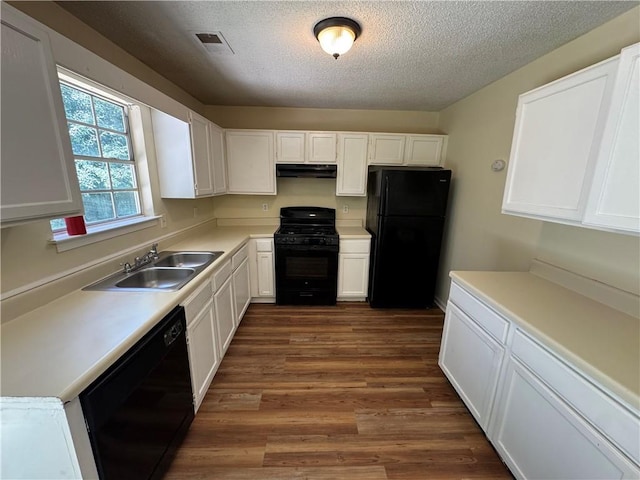 1050 Redan Trce, Stone Mountain, GA 30088 - kitchen featuring black appliances, a sink, under cabinet range hood, a textured ceiling, and dark wood-style floors