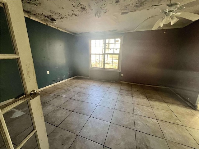 spare room featuring tile patterned flooring and ceiling fan