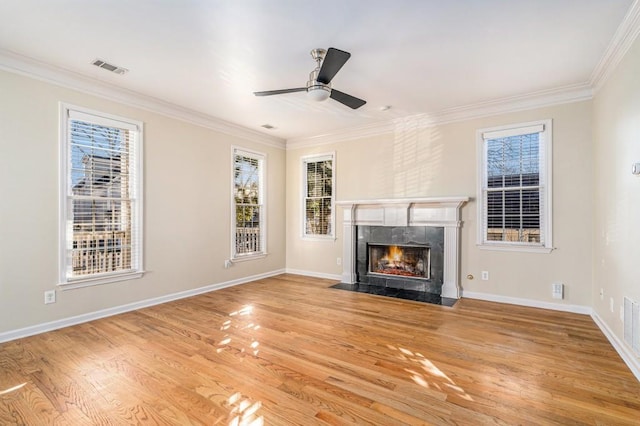 unfurnished living room featuring ceiling fan, light hardwood / wood-style floors, crown molding, and a tile fireplace