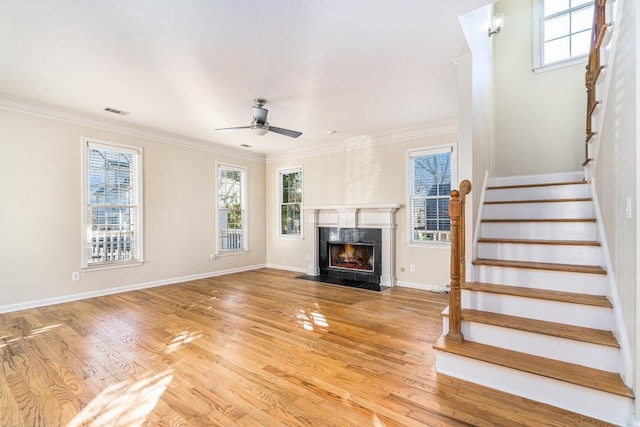 unfurnished living room with a high end fireplace, light hardwood / wood-style flooring, ceiling fan, and crown molding