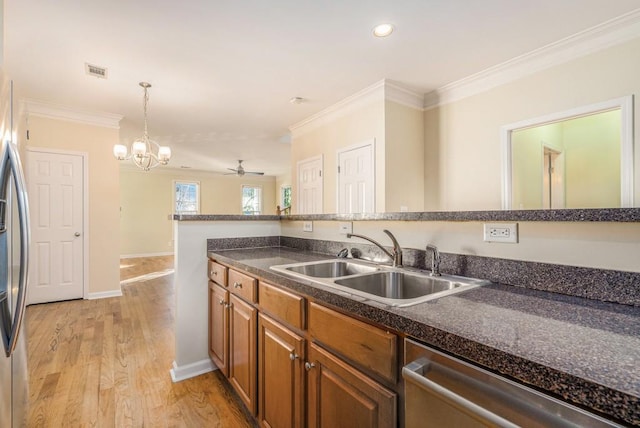 kitchen with ceiling fan with notable chandelier, sink, hanging light fixtures, light wood-type flooring, and stainless steel appliances