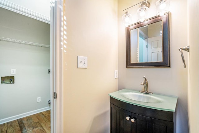 bathroom with crown molding, hardwood / wood-style floors, and vanity