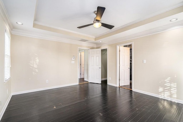 unfurnished room with dark hardwood / wood-style flooring, a raised ceiling, and crown molding