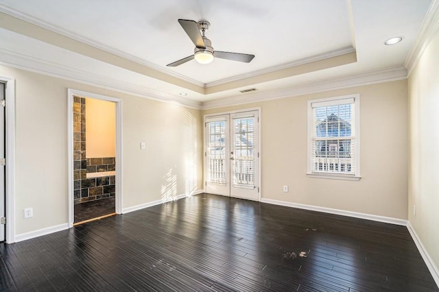 empty room with a tray ceiling, ceiling fan, dark hardwood / wood-style flooring, and crown molding