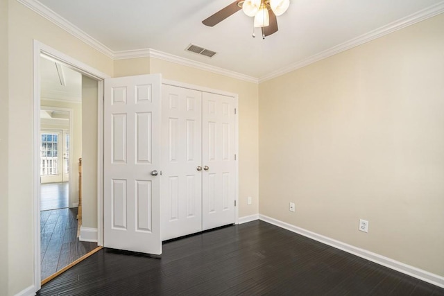 unfurnished bedroom featuring dark hardwood / wood-style flooring, ceiling fan, a closet, and crown molding