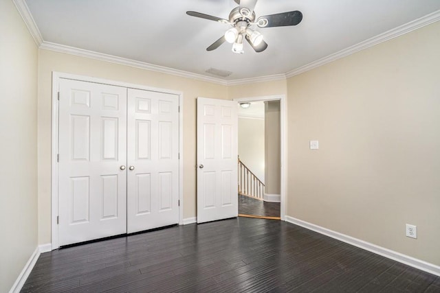 unfurnished bedroom featuring ornamental molding, a closet, ceiling fan, and dark wood-type flooring