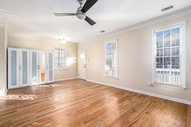 empty room featuring light wood-type flooring, ceiling fan, and crown molding