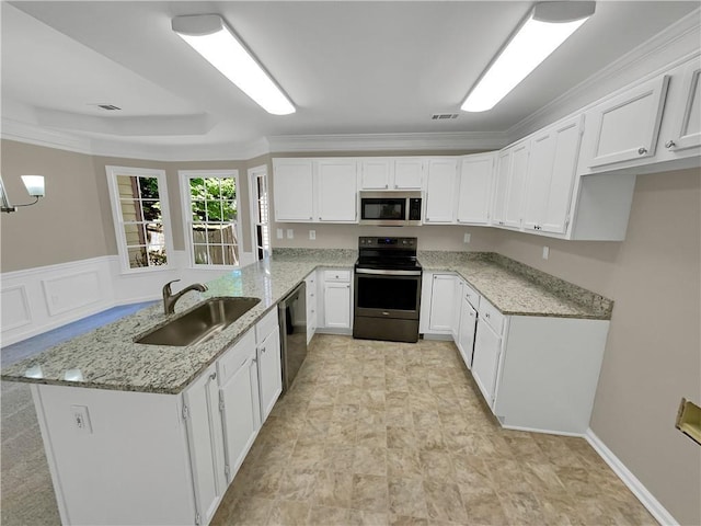 kitchen featuring kitchen peninsula, light stone counters, stainless steel appliances, sink, and white cabinets