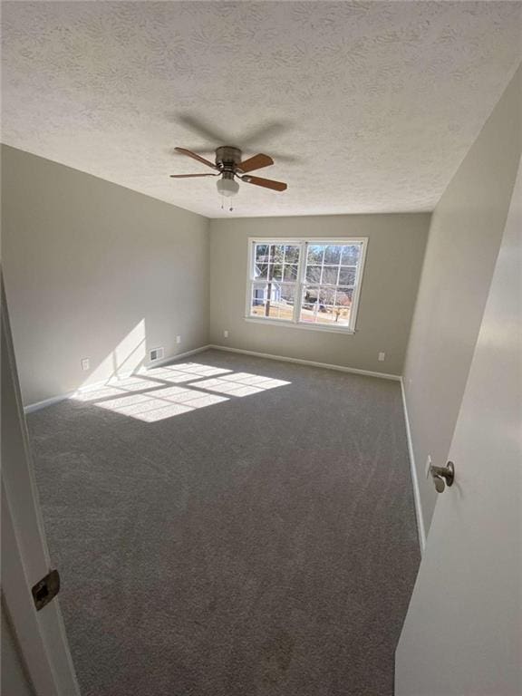 carpeted empty room with ceiling fan and a textured ceiling