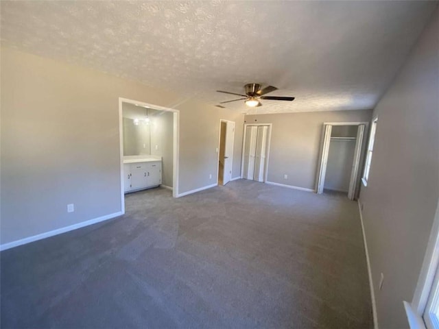 unfurnished bedroom featuring ceiling fan, connected bathroom, carpet floors, and a textured ceiling