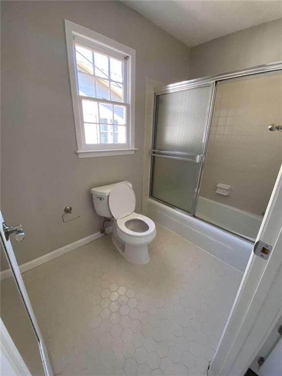 bathroom with shower / bath combination with glass door and toilet