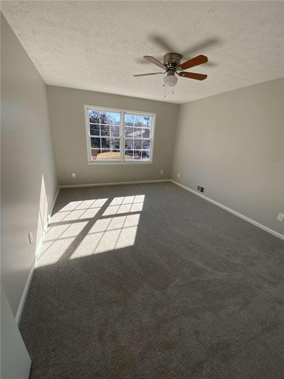 carpeted spare room featuring ceiling fan and a textured ceiling