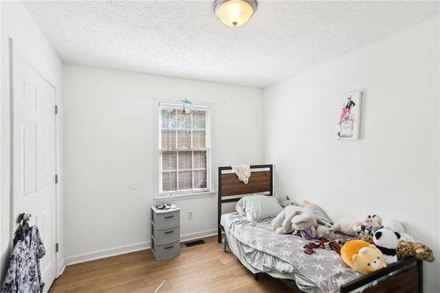 bedroom featuring a textured ceiling and light wood-type flooring