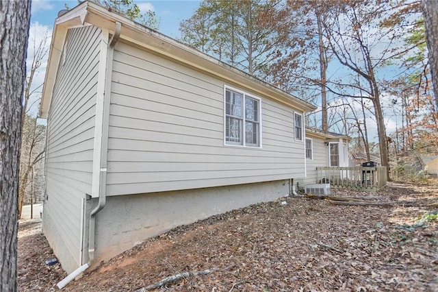 view of property exterior featuring a wooden deck and central AC