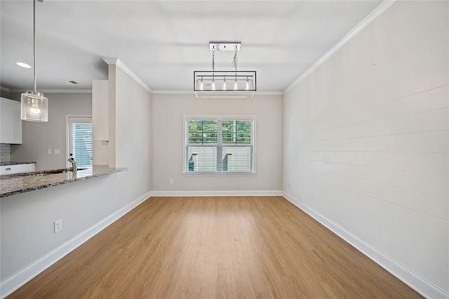 interior space with wood finished floors, baseboards, and ornamental molding