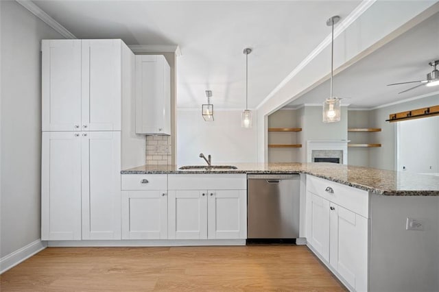 kitchen featuring stone counters, light wood-type flooring, stainless steel dishwasher, and crown molding