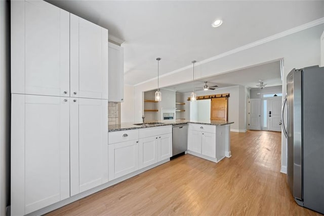 kitchen featuring ornamental molding, light wood-style flooring, a peninsula, white cabinets, and stainless steel appliances