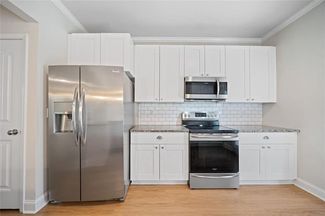 kitchen with light stone counters, stainless steel appliances, and ornamental molding