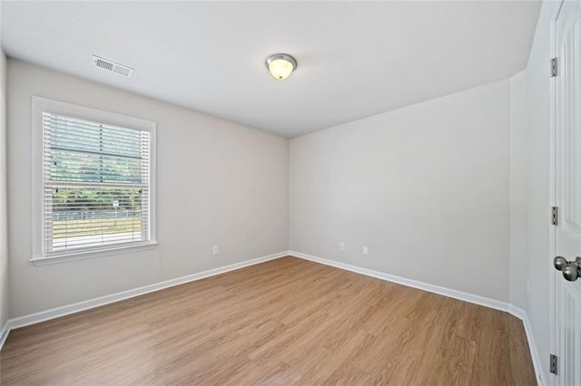 unfurnished room with visible vents, light wood-style flooring, and baseboards