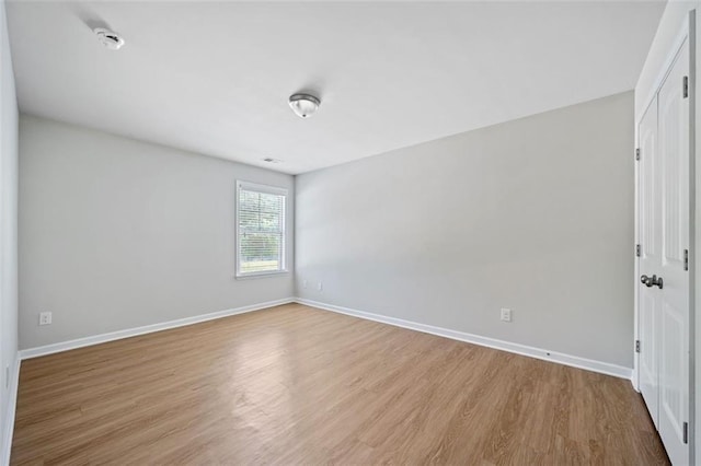 spare room with wood finished floors and baseboards