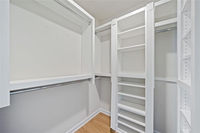 walk in closet with wood finished floors