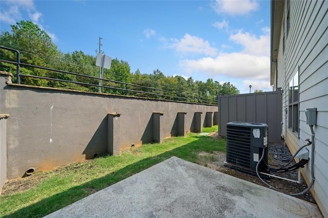 view of yard with a patio, central air condition unit, and fence