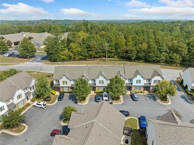 drone / aerial view featuring a residential view and a wooded view