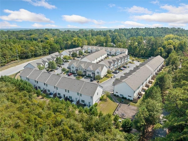 birds eye view of property featuring a wooded view and a residential view