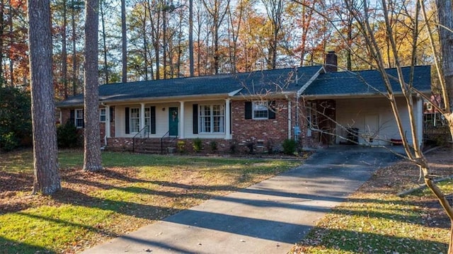 single story home featuring a front lawn, covered porch, and a carport